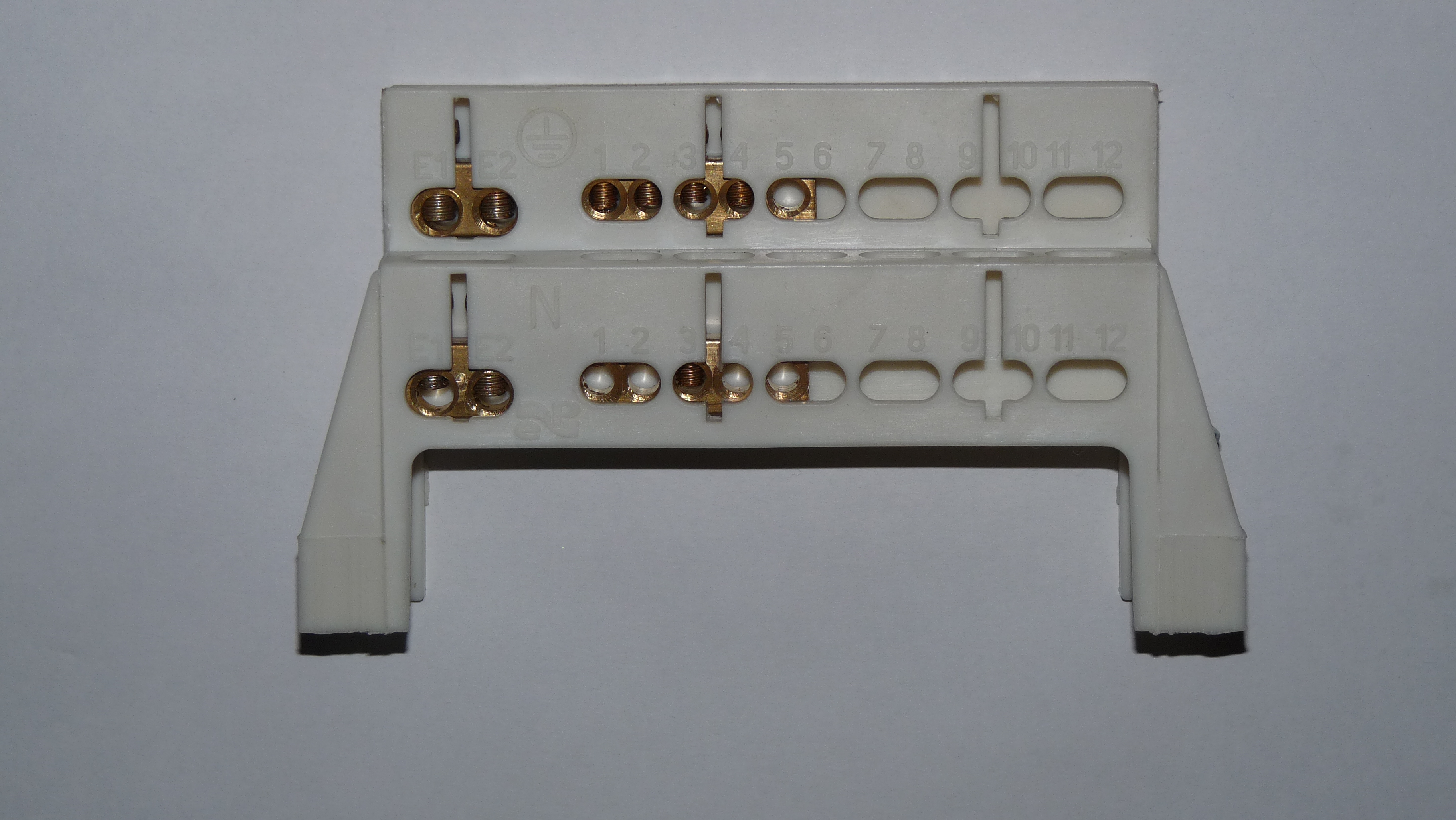 Two busbars with brass terminals: the upper one marked with the earthing symbol, the lower one with the letter N